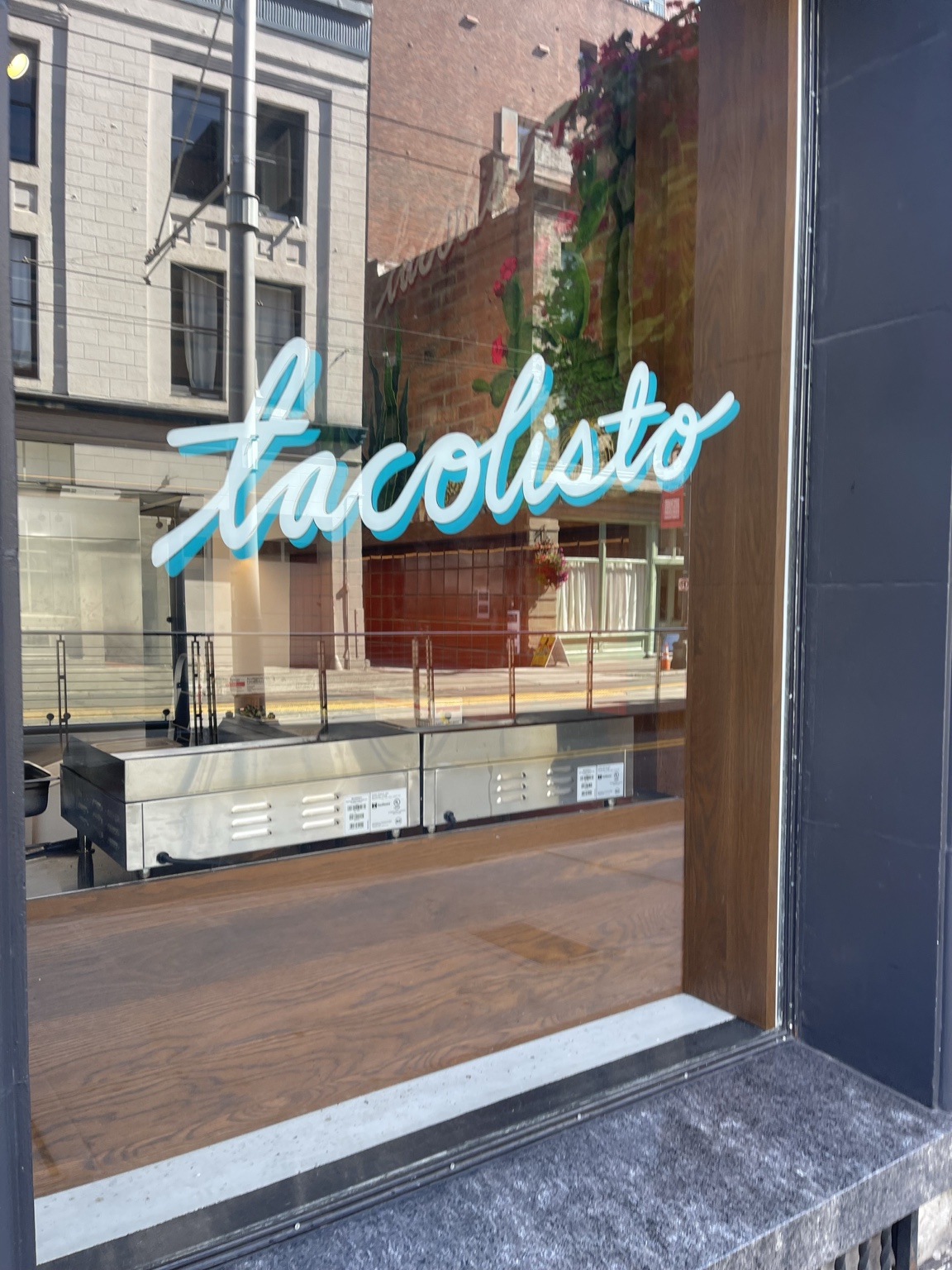 Tacolisto lettering on a restaurant window.
